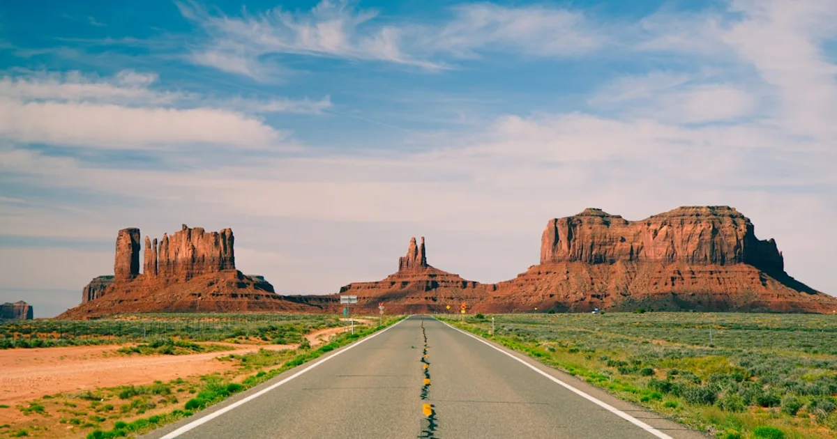 Desert highway leading to monument valley rock formations