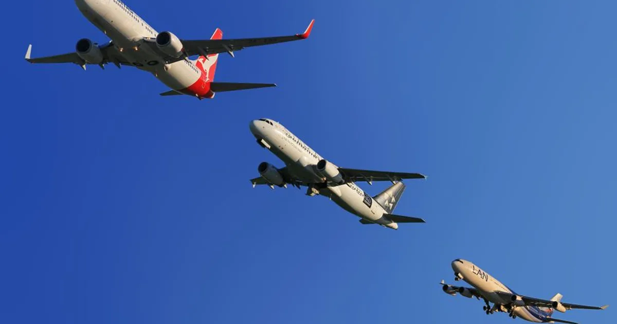 Three commercial airplanes soaring through a clear blue sky, highlighting aviation technology.