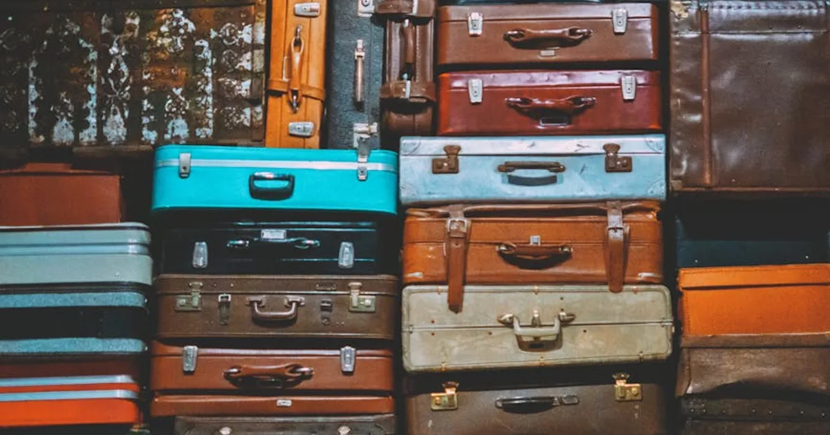 A colorful assortment of vintage suitcases stacked together, creating an artistic display.
